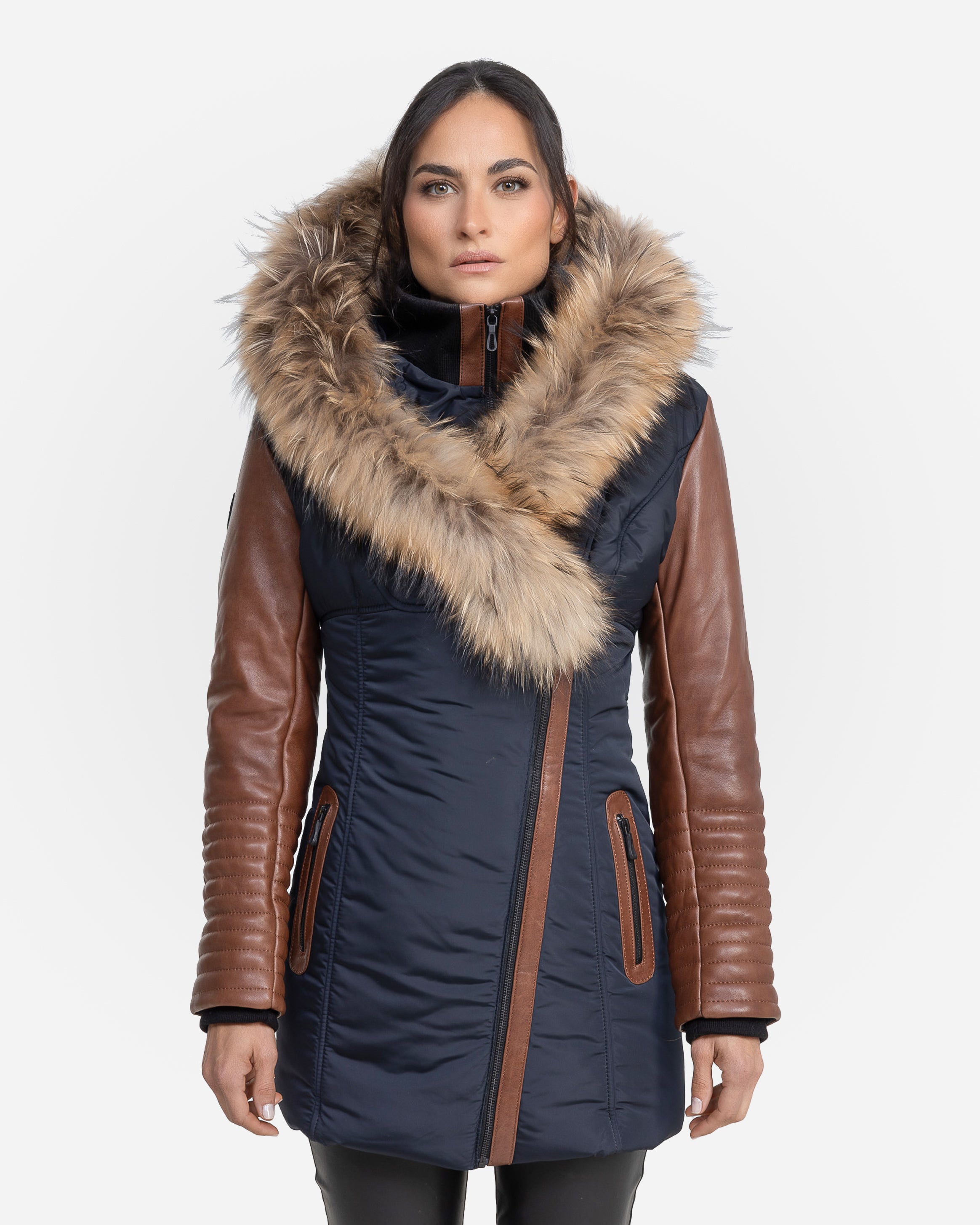 A woman wearing a navy winter coat with leather sleeves and a fur-lined collar.